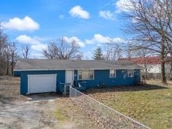 single story home with a garage and driveway