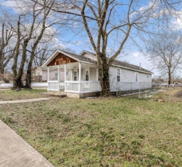 view of front of property featuring fence, a porch, and a front yard