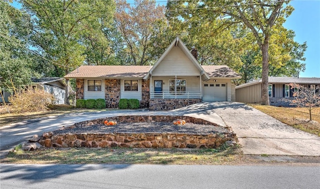 view of front of property with driveway, stone siding, and an attached garage