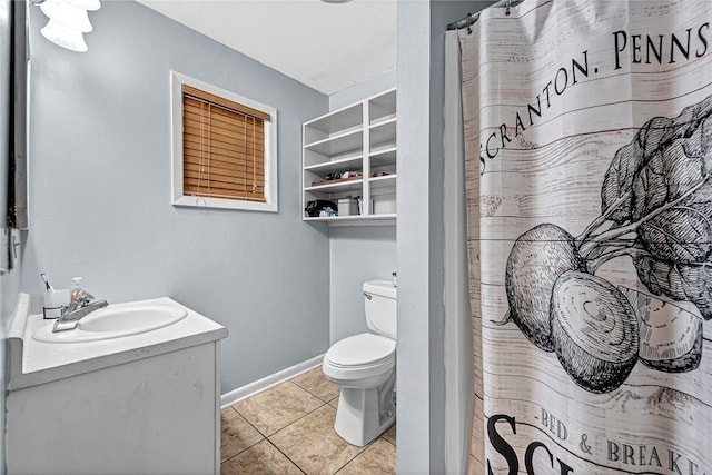 bathroom featuring toilet, vanity, baseboards, and tile patterned floors