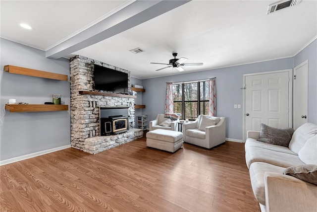 living area featuring visible vents, ceiling fan, baseboards, and wood finished floors