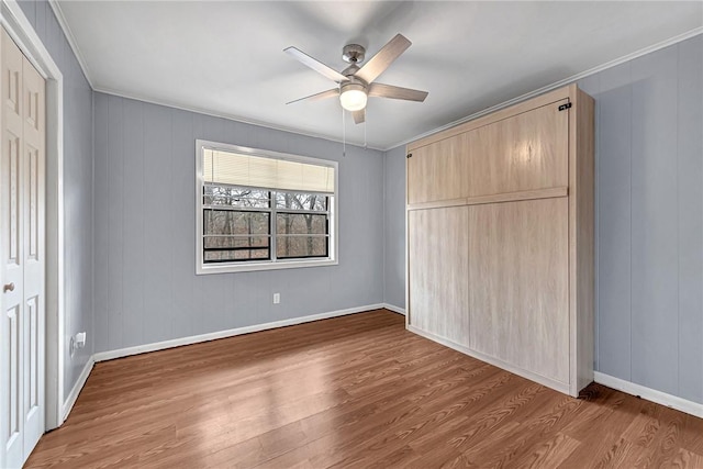 unfurnished bedroom with crown molding, a closet, and wood finished floors