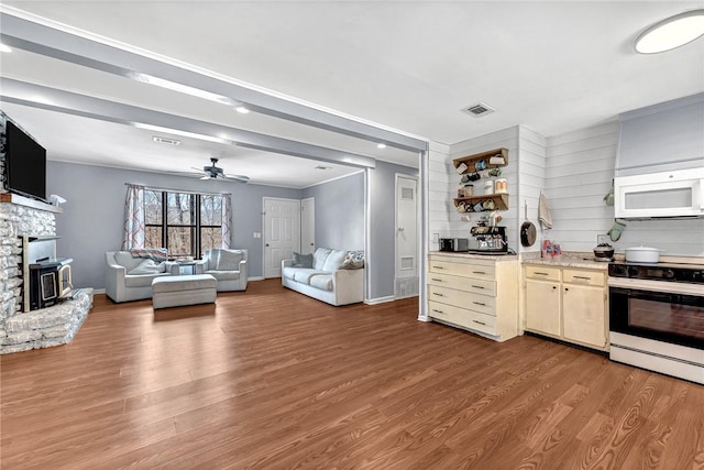 kitchen featuring white appliances, baseboards, visible vents, and wood finished floors