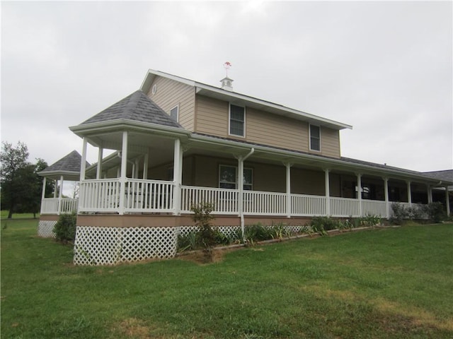 back of house featuring a porch and a lawn