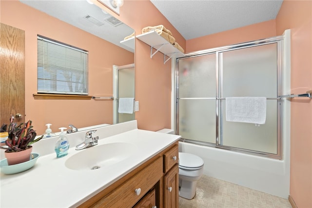 full bathroom featuring shower / bath combination with glass door, visible vents, toilet, vanity, and a textured ceiling