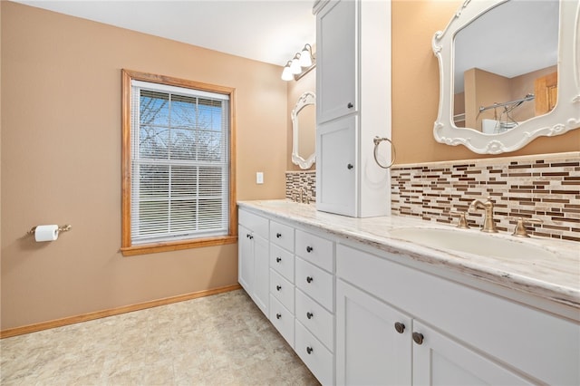 bathroom with double vanity, baseboards, a shower, decorative backsplash, and a sink