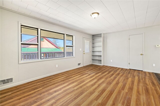 15 White St, Eureka Springs, AR 72632 - spare room featuring baseboards, wood finished floors, visible vents, and built in features