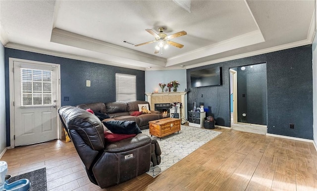 living area featuring a raised ceiling, visible vents, and hardwood / wood-style flooring