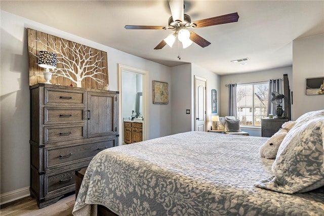 bedroom featuring baseboards, visible vents, connected bathroom, ceiling fan, and wood finished floors