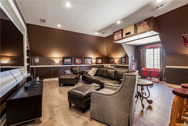 home theater featuring visible vents, baseboards, and wood finished floors