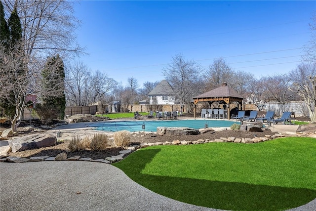 view of swimming pool featuring a patio, a yard, fence, and a fenced in pool