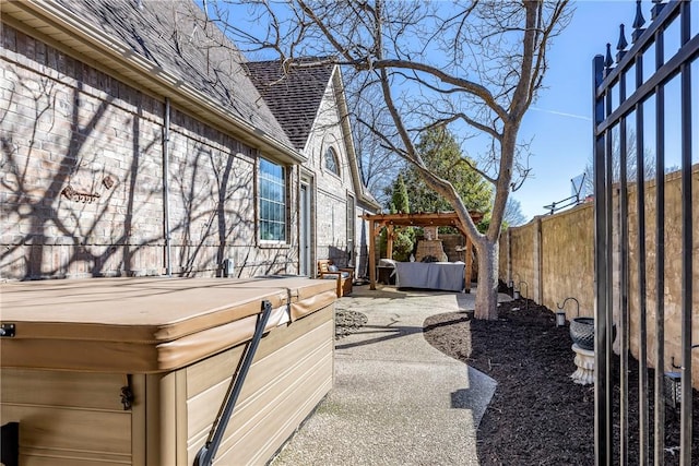 view of patio with a fenced backyard and a hot tub