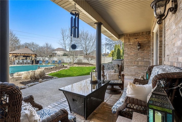 view of patio featuring outdoor lounge area, fence, and a gazebo