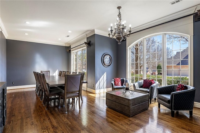 dining room with ornamental molding, wood finished floors, and baseboards