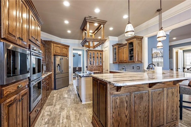 kitchen with appliances with stainless steel finishes, an island with sink, a breakfast bar area, and tasteful backsplash