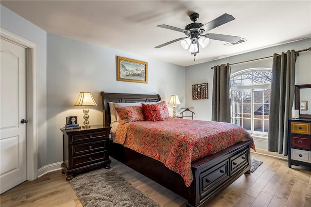 bedroom with light wood-type flooring, visible vents, ceiling fan, and baseboards