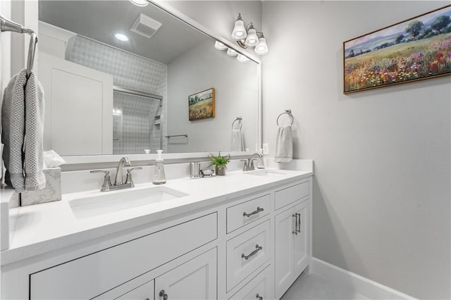 bathroom featuring double vanity, a sink, visible vents, and a shower stall