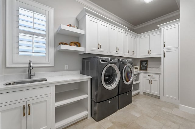 laundry area with cabinet space, ornamental molding, separate washer and dryer, and a sink