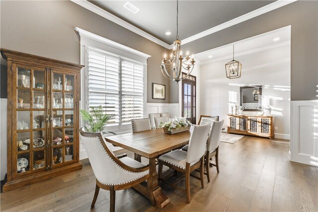 dining space featuring a chandelier, crown molding, wood finished floors, and recessed lighting