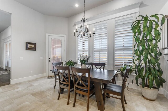 dining space featuring a chandelier and baseboards