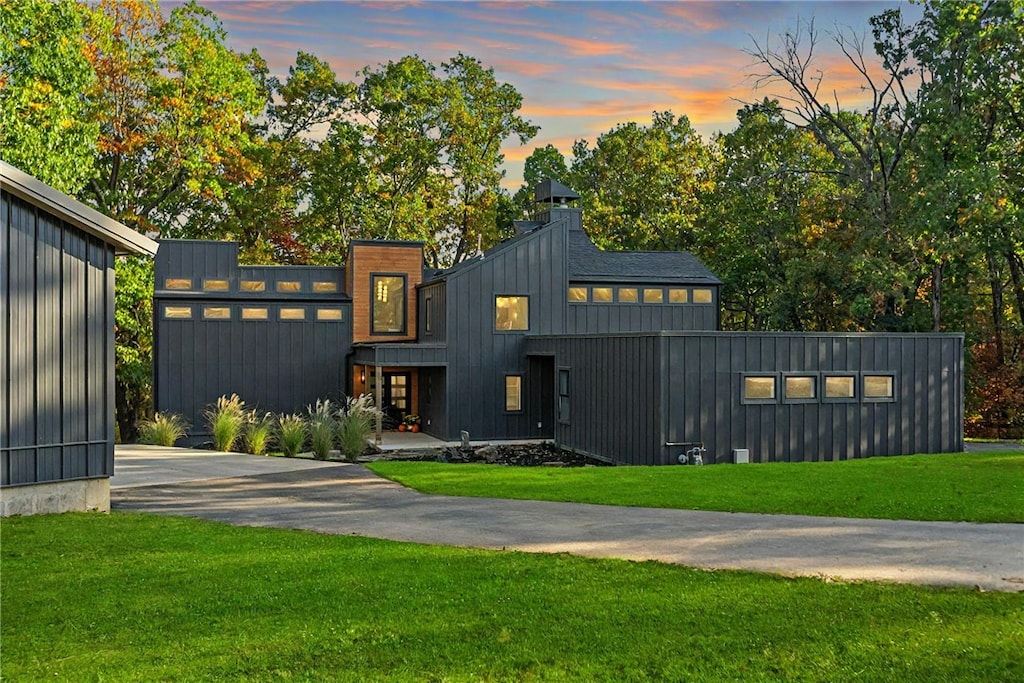 view of front of property with driveway, a front lawn, and board and batten siding