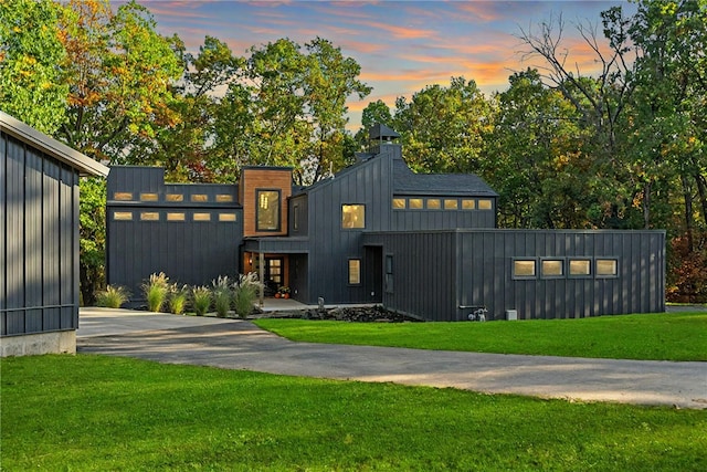 view of front of property with driveway, a front lawn, and board and batten siding