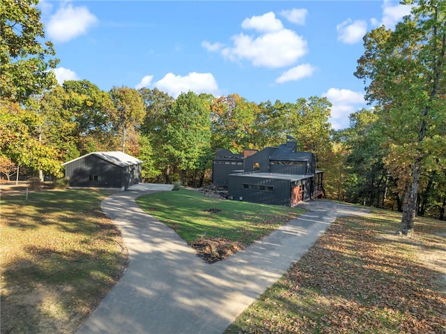 view of front of property featuring a front lawn and an outdoor structure