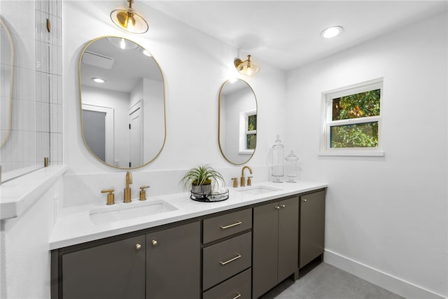 full bathroom featuring double vanity, baseboards, a sink, and recessed lighting