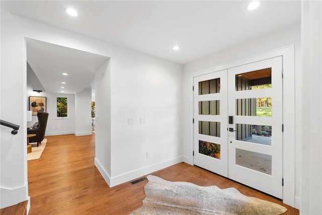 doorway with light wood finished floors, french doors, visible vents, and recessed lighting