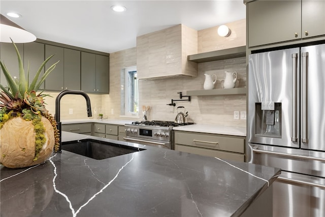 kitchen featuring stainless steel appliances, decorative backsplash, a sink, and gray cabinetry