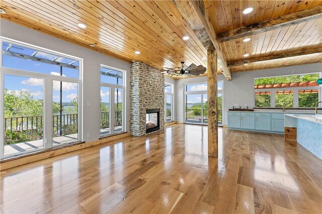16103 E Ar 12th Hwy, Rogers, AR 72756 - unfurnished living room with wood ceiling with exposed beams, recessed lighting, light wood finished floors, a fireplace, and healthy amount of natural light