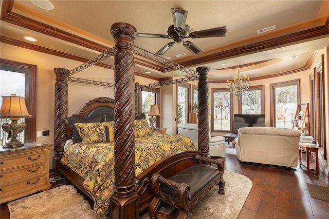 bedroom featuring visible vents, a raised ceiling, dark wood-style flooring, and ornamental molding