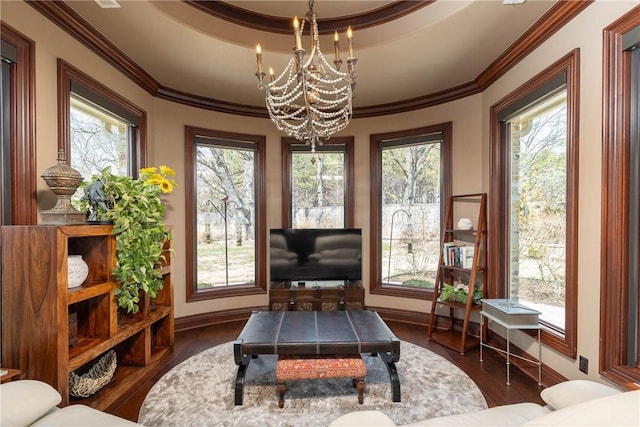 sunroom / solarium featuring a wealth of natural light, a raised ceiling, and an inviting chandelier