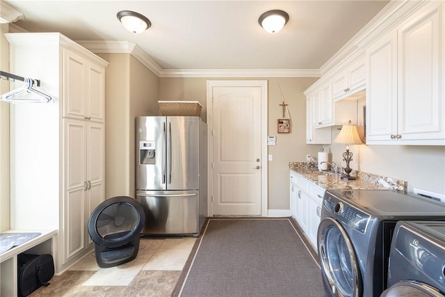 laundry room featuring crown molding, light tile patterned floors, cabinet space, a sink, and washer and dryer