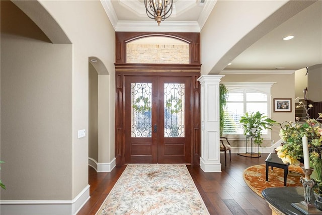 foyer entrance with crown molding, french doors, and dark wood finished floors