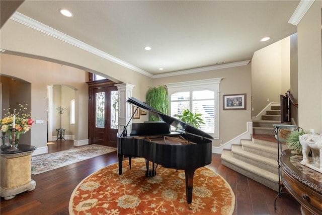 sitting room with a wealth of natural light, arched walkways, stairs, and hardwood / wood-style flooring