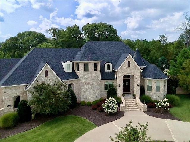 french country style house with stone siding and roof with shingles