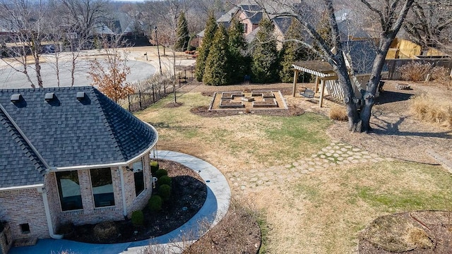 view of yard featuring fence, a vegetable garden, and a pergola