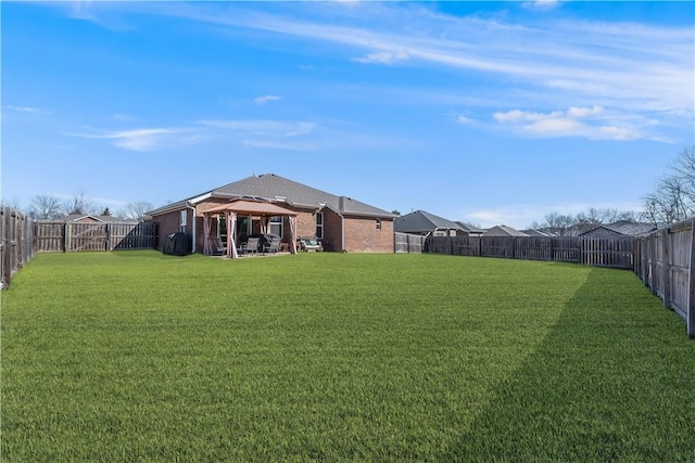 view of yard featuring a gazebo and a fenced backyard