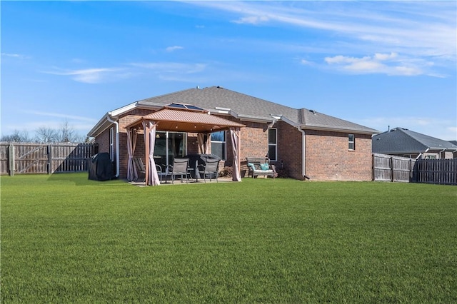 back of property with a patio area, a yard, brick siding, and a gazebo