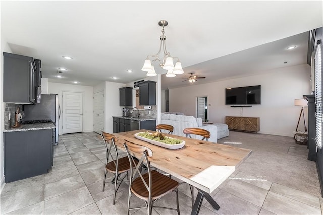 dining area featuring ceiling fan with notable chandelier, baseboards, light tile patterned flooring, and recessed lighting