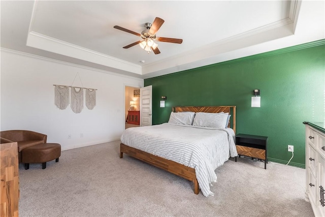 bedroom with ornamental molding, a tray ceiling, and carpet flooring