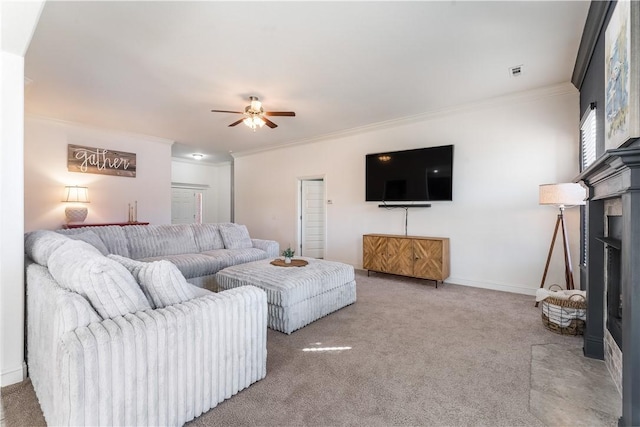 living room with carpet floors, a fireplace, crown molding, and ceiling fan