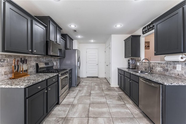 kitchen with light tile patterned floors, visible vents, light stone countertops, stainless steel appliances, and a sink