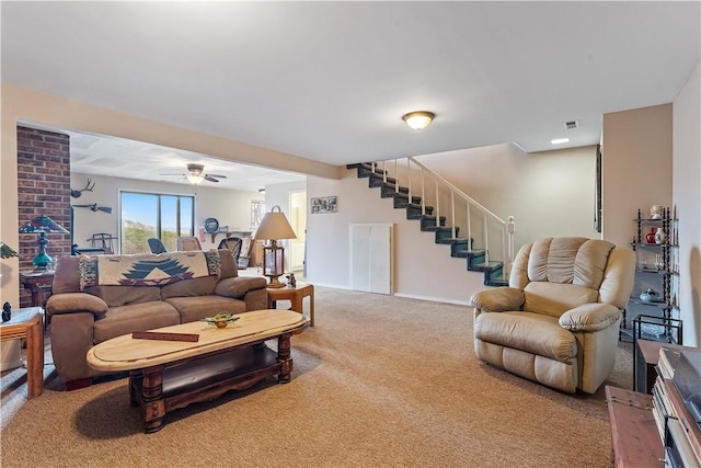 carpeted living room featuring ceiling fan, baseboards, and stairs