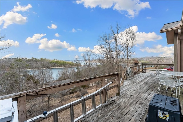 deck featuring outdoor dining space and a water view