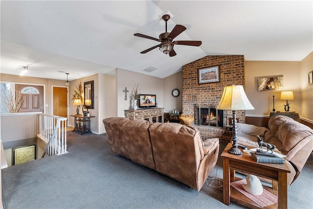 living area featuring a fireplace, visible vents, vaulted ceiling, and carpet flooring