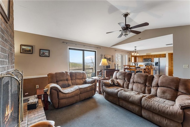 living area with lofted ceiling, a brick fireplace, ceiling fan, and carpet flooring