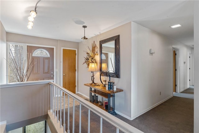 entrance foyer with rail lighting and baseboards