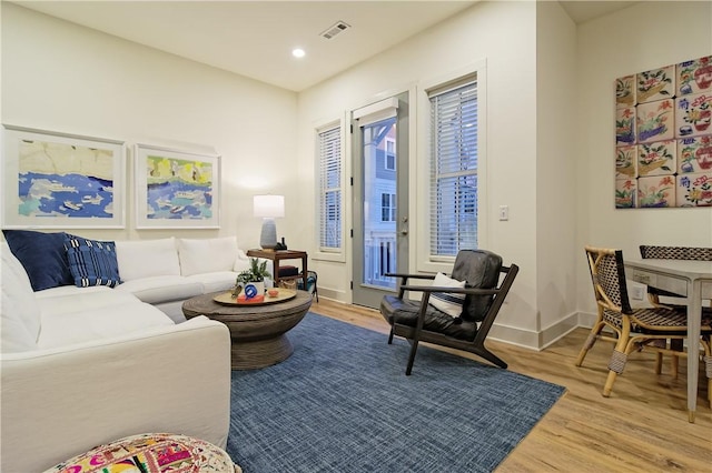 living area with light wood-type flooring, baseboards, visible vents, and recessed lighting